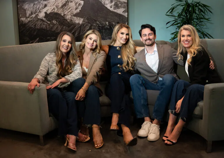 Business team relaxing on a gray couch with mountain art in background