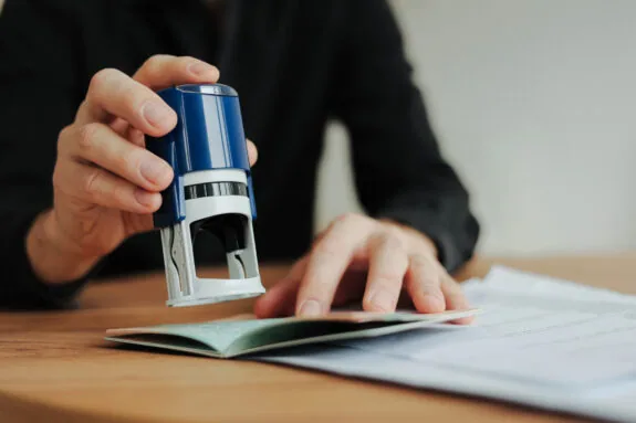 Man border control worker puts a stamp in the passport