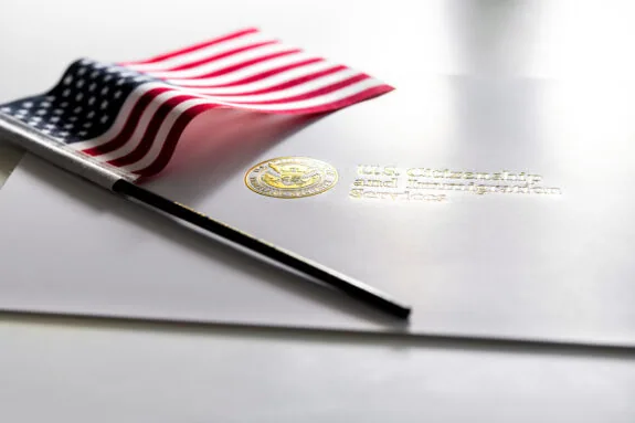 U.S. Citizenship and Immigration Services envelope, white folder for naturalization certificate